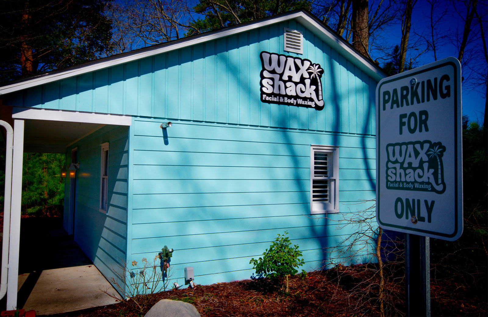 Exterior photo of Wax Shack showing the signage and custom parking sign