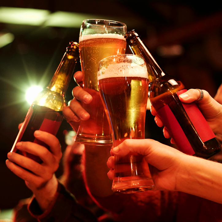 hands in the air cheersing beers
