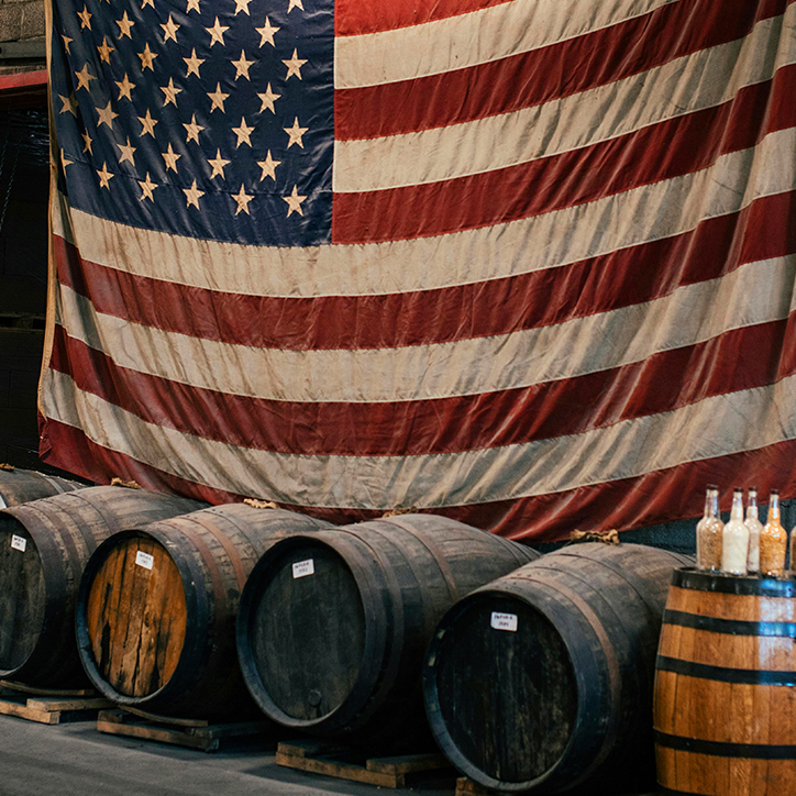 whisky barrels in front of an American flag whisky barrels in front of an American flag